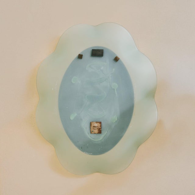 A rare Italian ‘Onda’ wall mirror designed by Nanda Vigo for Glas Italia in the 1980s. The oval mirror glass gracefully...