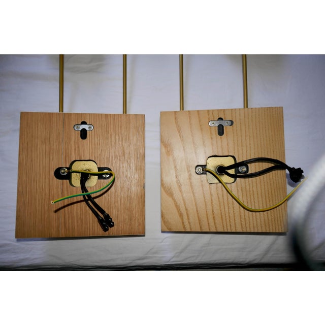Pair of "Sano" wall sconces, left and right, in a gilt bronze patina with a sycamore wood base, designed by Aymeric...