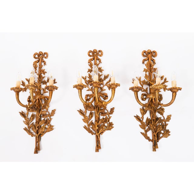 A set of six antique Louis revival ormolu three branch wall lights, circa 1920 in date. They each feature three spiral-...