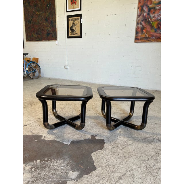 Vintage ebonized side tables with brass accents, featuring a chunky, tubular design and smoked glass tops. In excellent...