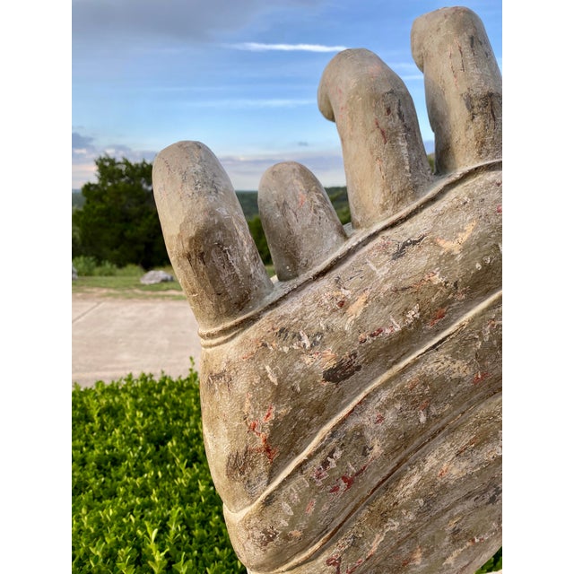 Wooden hand sculpture on metal stand. This item is made of solid wood and is painted with a gesso finish.