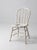 This vintage Windsor bow back chair features a beautifully worn cream-painted finish with delicate turned spindle...