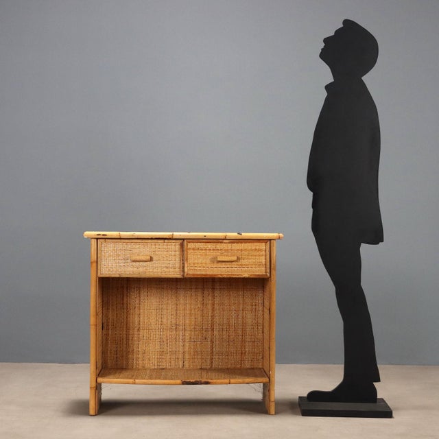Cabinet with a pair of under-counter drawers. Made of bamboo, the wooden frame is covered with woven rattan fabric. This...