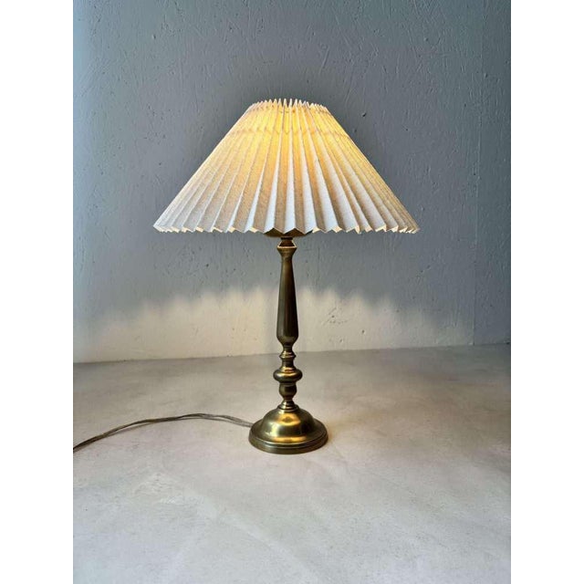 This atmospheric brass table lamp from the 1960s features a new pleated ecru shade. A sleek and elegant design that blends...