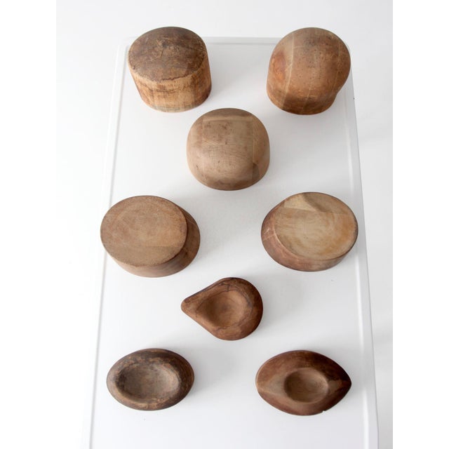This collection of eight early 20th-century wooden millinery hat blocks includes a variety of crown blocks and finishing...