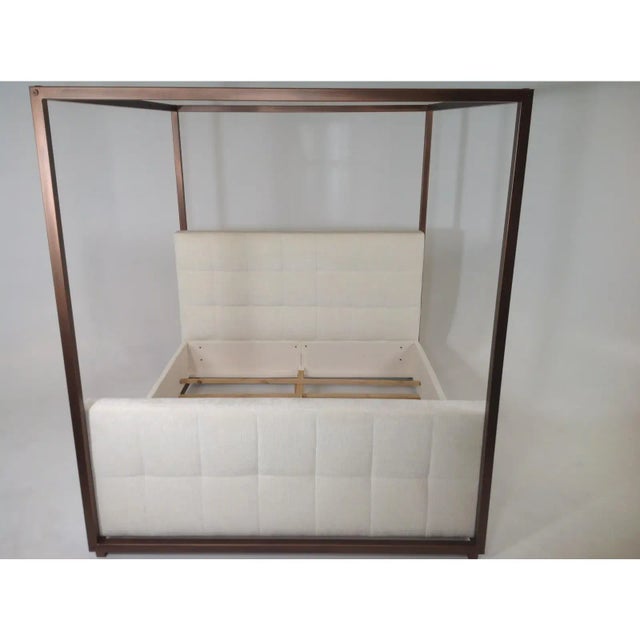 Stunning canopy Cal king bed. The bed is upholstered in a cream colored chenille. The frame is aluminum and has a copper...