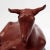 A recumbent goat sculpture in red painted terracotta pottery mounted on an integral wooden plinth. By J Stephen Lewis...