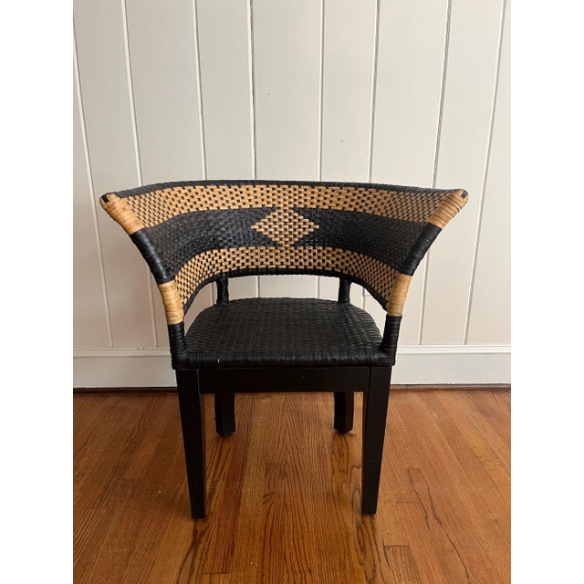 Vintage black and rattan barrel-back arm chair. Stripe design on seat back with diamond shape at center.