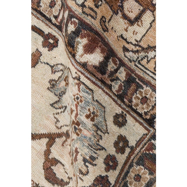 An unusual early 20th century Tabriz Persian rug, the sand field with a spacious lattice of vinery and bold leafy...