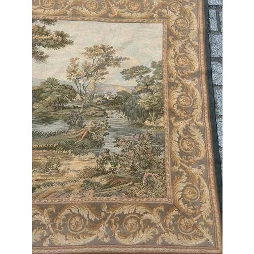 Exquisite French tapestry featuring a charming scene of a fountain in nature among the trees which are surrounded by...