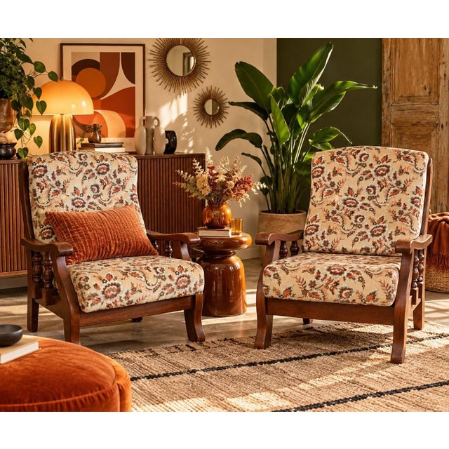 A beautiful pair of 1970s lounge chairs in solid wood with a dark brown stain. The frame features turned spindle supports...