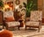 A beautiful pair of 1970s lounge chairs in solid wood with a dark brown stain. The frame features turned spindle supports...