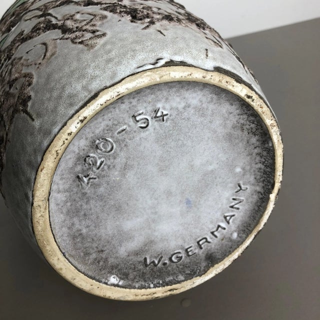 This original vintage vase was produced in the 1970s in Germany. It is made of ceramic pottery in fat lava optic with...