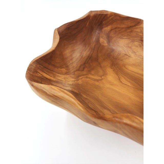 This exquisite decorative bowl is hand-carved in Peru from a single block of rich olive wood, revealing warm honey tones...