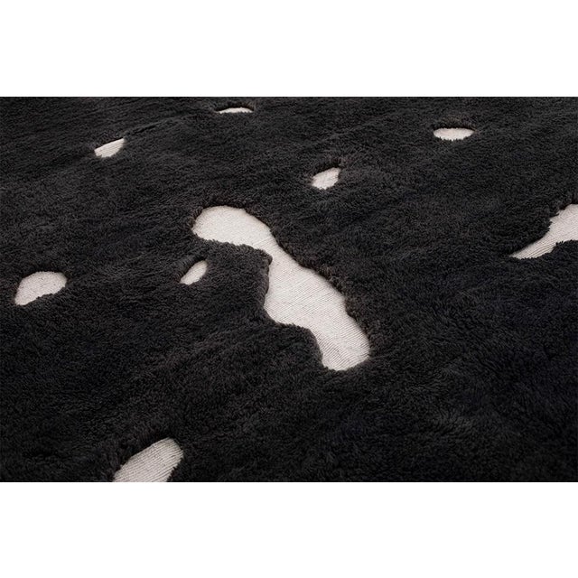 Constellations scattered across a field of night. Small organic bursts of ivory float freely across a deep midnight black...