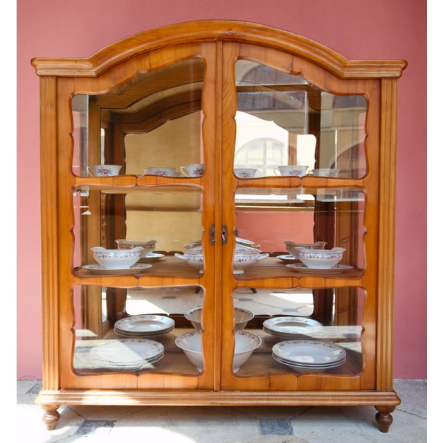 Elegant display case from the Biedermeier period with harmonious proportions, a gracefully shaped upper cornice and...