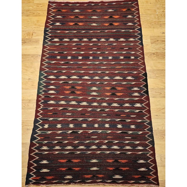Handwoven in Morocco during the mid-1900s, this vintage kilim is a riot of geometry and color that speaks to the bold...