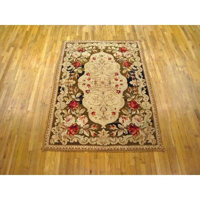 Antique Portuguese needlepoint flat-weave rug handwoven with a symmetrical floral design, ivory center, and bold splashes...
