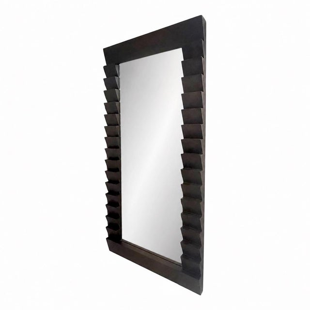 The Elkins Full-Length Mirror by Arteriors features a dramatic sawtooth frame crafted from laminated mango wood in a rich...
