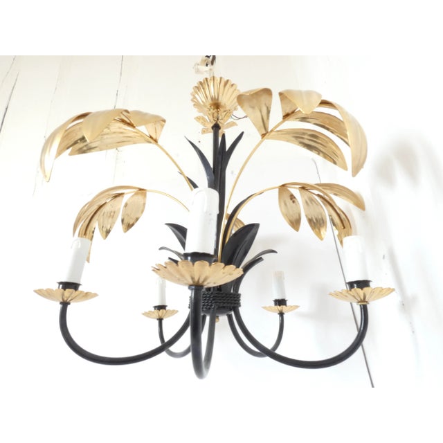 French vintage Black and gold tole drop chandelier. It has gold palm leaves and a black base. Perfect for a mid century...