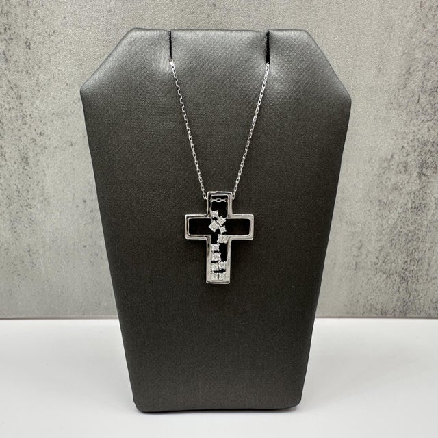 This scattered diamond cross necklace is crafted in sterling silver and features a contemporary cross pendant accented...