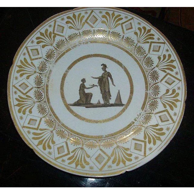 A fine neoclassical Coalport plate decorated with a central grisaille reserve showing a classical scene. Exceptional gilt...