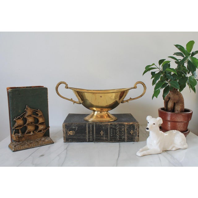 Vintage oval brass pedestal bowl w/ ornate brass handles. Made in India. Some patina to brass. Some residue inside bowl....