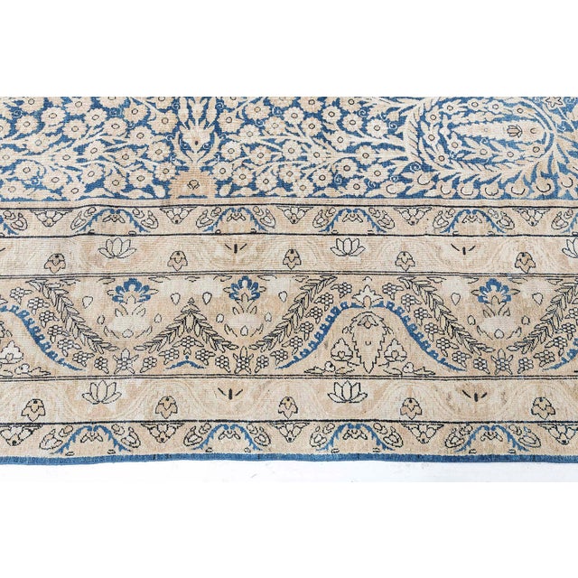 A late 19th century Persian Kerman rugs for sale, the indigo field with an allover symmetrical pattern of camel-colored...