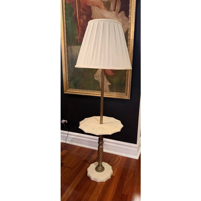 A substantial vintage floor lamp blending French Neoclassical styling with everyday functionality. The design features a...