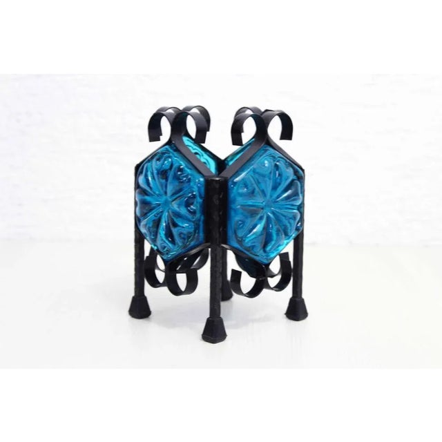 Beautiful iron and blue glass candleholder This candlestick reminds us of the productions of Erik Hoglund and the charm...