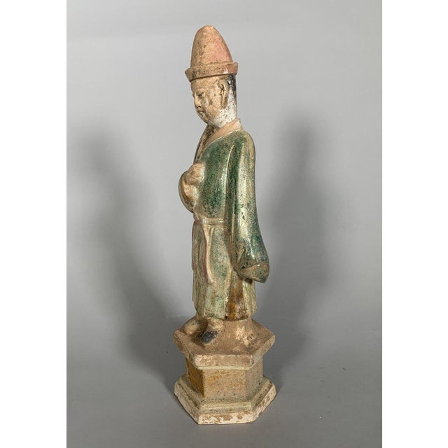 Statuette of a servant known as a "Mingqi," China - Ming Dynasty (1368-1644). Terracotta sculpture with green and brown...