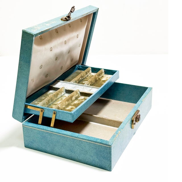 This charming vintage jewelry box features a classic mid-century design with a vibrant turquoise leatherette exterior with...