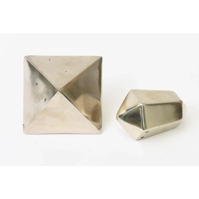 These vintage sculptural objects or paperweights are brass that has been polished down to a light silver color with brass...