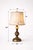 Elegant vintage urn-form table lamps with rich patina and original hand-painted floral silk shades, offering a warm,...