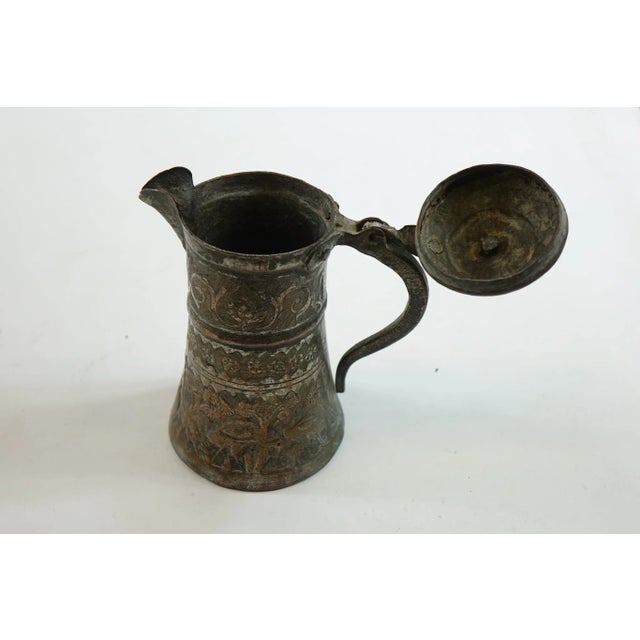 This image depicts an antique Persian copper water container, likely from the 19th century or earlier. The vessel is...