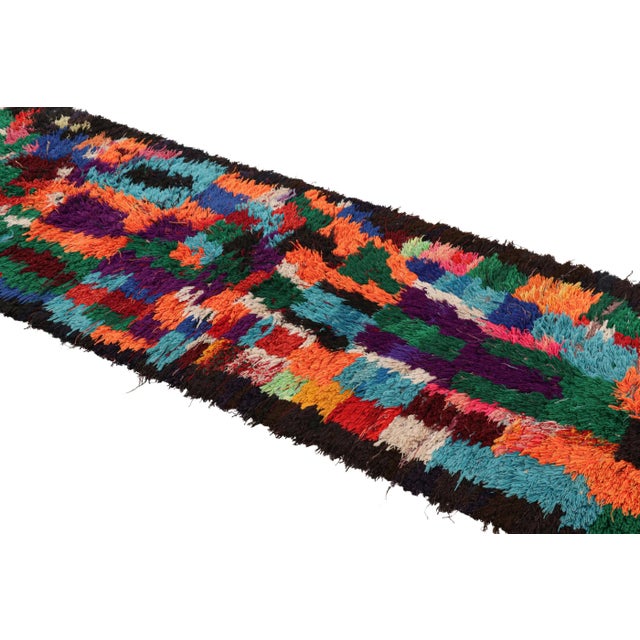 Hand-knotted in wool and originating from Morocco circa 1950-1960, this 3x9 vintage Moroccan rug is an extremely rare...