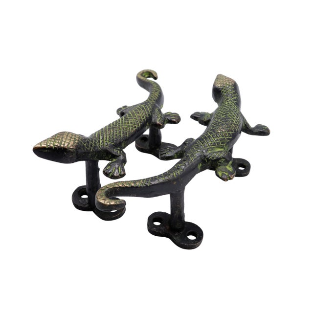 A pair of green brass lizard door handles or cabinet pulls. Pressed with simple details to convey skin, eyes and toes....