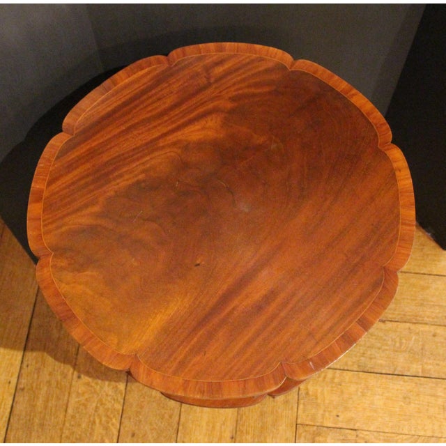 Early 20th century revolving bookcase side table, English. Lobed surfaces. Mahogany with mahogany crossbanding. Raised on...