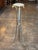 Three curved steel legs headed by brass rams' heads and ending in brass hoof feet, joined by a brass ring, support a small...