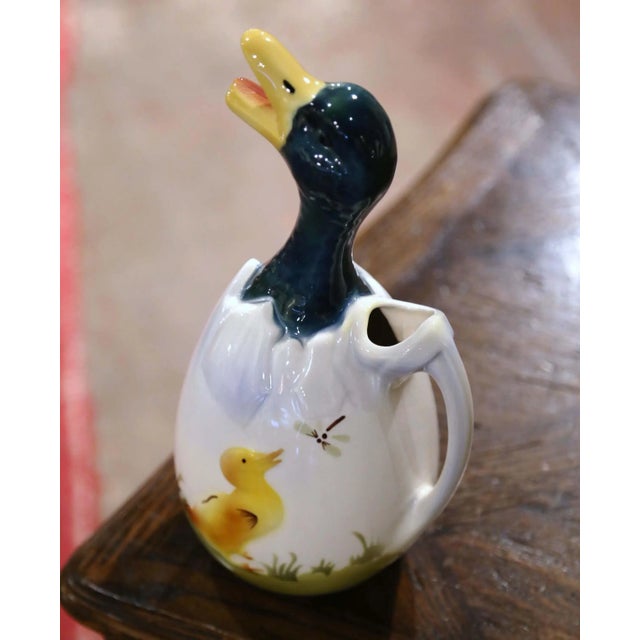 Whimsical in form and richly colored, this antique barbotine pitcher depicts a young duck emerging from a broken eggshell....