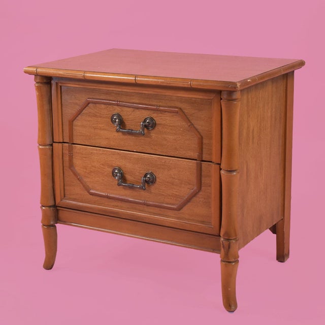 A pair of faux bamboo nightstands by Broyhill, each with two drawers framed by faux bamboo corner posts and fitted with...