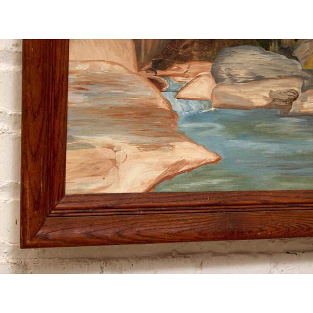 A charming vintage landscape painting depicting a rushing mountain river surrounded by large rocky banks, evergreen trees,...