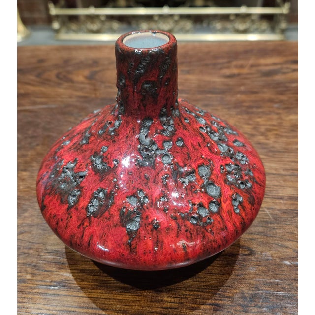 A vintage ceramic Fat Lava vase featuring its signature red and black cratered glaze, crafted in a unique UFO shape.