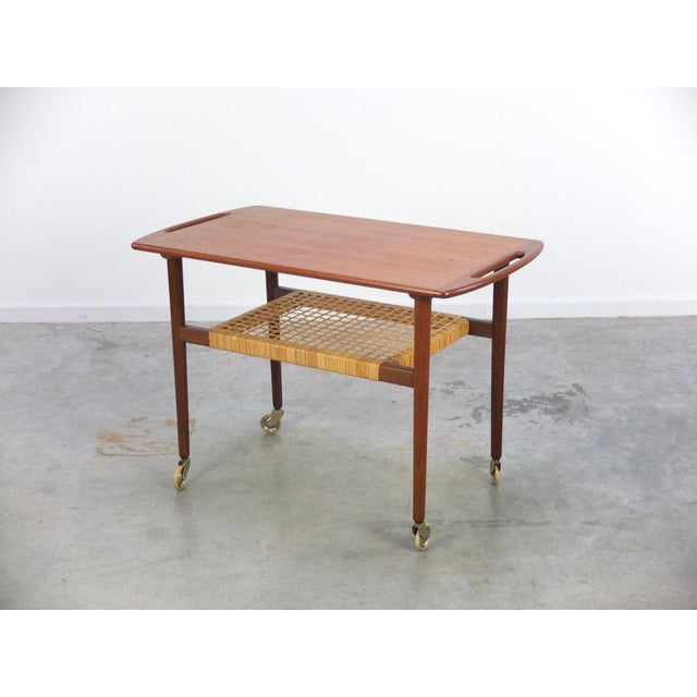 Very elegant and unique serving trolley produced in Denmark during the 1960s. Made of teak wood and underneath the top we...