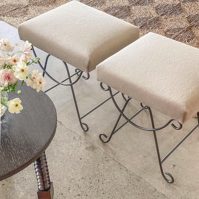 Beautiful iron stools with curved and looped base painted in a matte black finish. Rectangular cushioned seat upholstered...