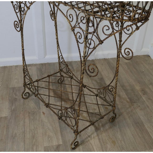 A Regency Wire Work Plant Stand The planter has an upper basket and a lower shelf, it stands on curled feet. This is an...