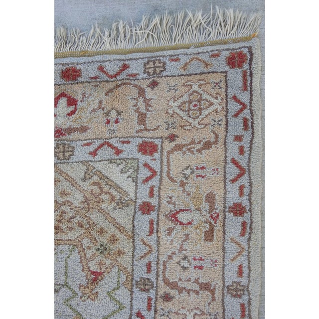 Soft shades of red, grey and peach with touches of brown and green, accent this wool Oushak rug from Turkey. The ends are...