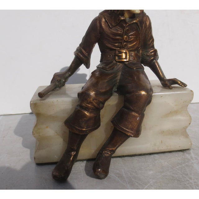 Hirsch bookend figure of the Pirate with a gun. A zinc figure on a block of white banded onyx. Polychromed in bronze-...