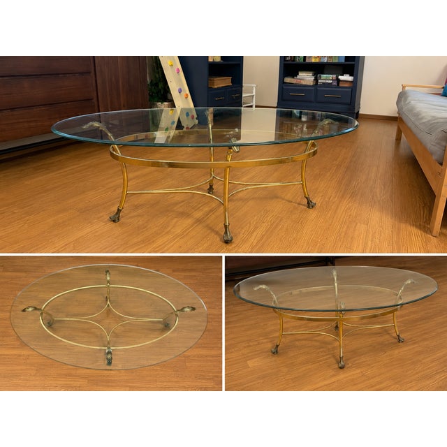 Stunning vintage Hollywood Regency oval coffee table featuring a gorgeous, bright gold-toned frame with elegant curved...