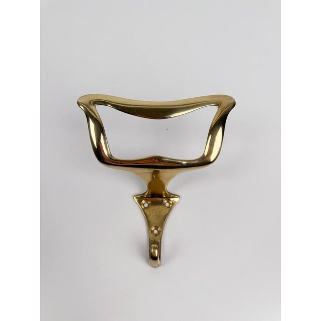 Elegant pair of mid-century Italian wall coat hooks, crafted in brass and inspired by the design style of Osvaldo Borsani....